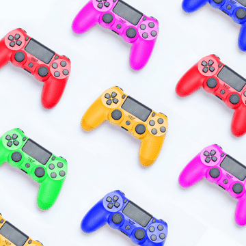 Pink, red, yellow, green and blue game controllers on a white background