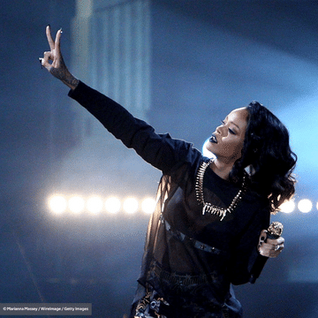 Rihanna performing while holding a microphone in her hand