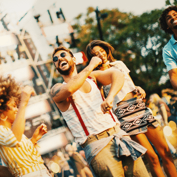 Photo of a group of friends dancing at a festival.