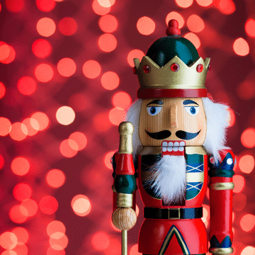 Painted nutcracker in front of glittery red background