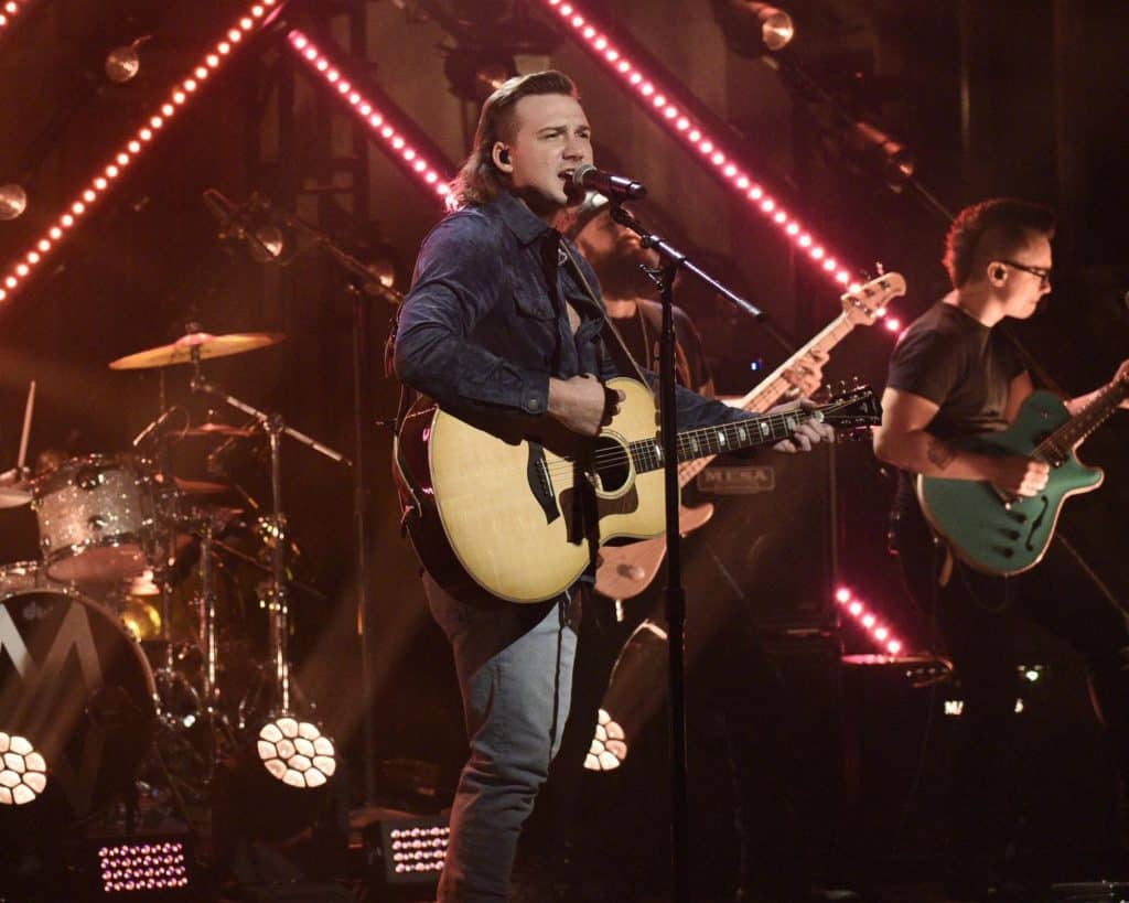 Morgan Wallen playing a guitar and singing