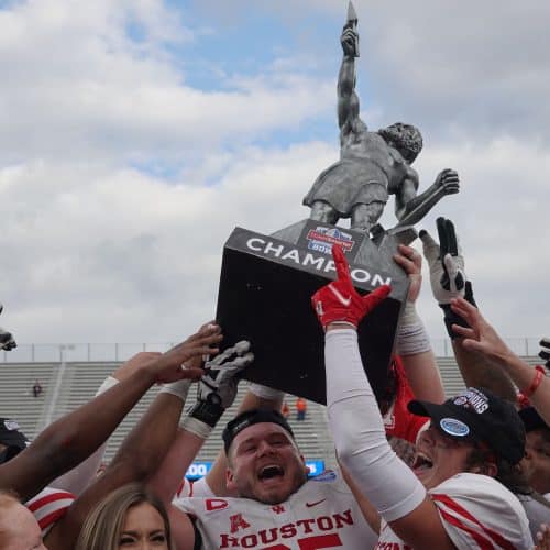 Houston football players holding TicketSmarter Birmingham Bowl trophy after winning the 2021 game.