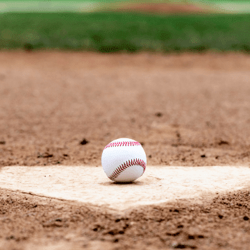 A baseball on top of the home plate.