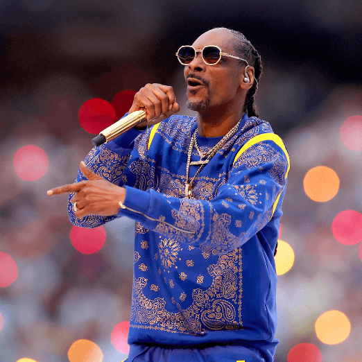 Image of Snoop Dogg in a blue-gold paisley jumpsuit and gold-rimmed sunglasses while performing at the 2022 Super Bowl half-time show