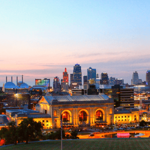 Image of Union Station in downtown Kansas City at dusk with a partially lit skyline