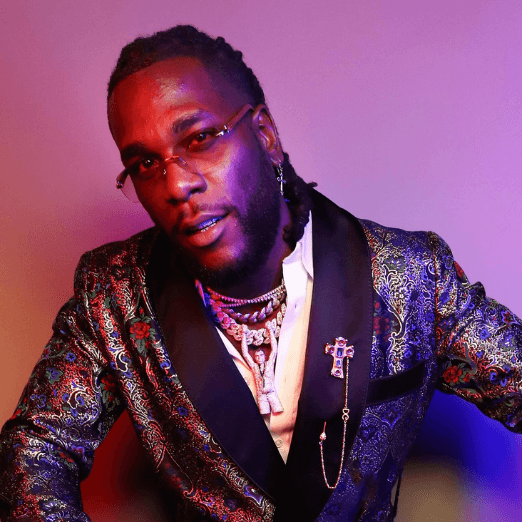 Image of Burna Boy wearing tinted glasses and a metallic suit