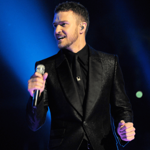Photo of Justin Timberlake holding a microphone while performing on stage.