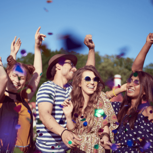 Image of people dancing outside while confetti is falling